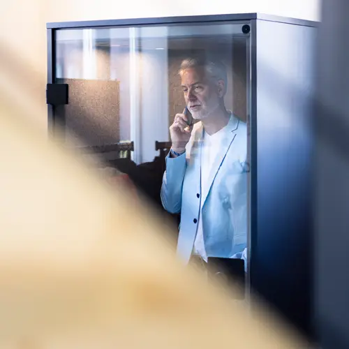 Mann telefoniert in einer Telefonzelle im KoWerk 76